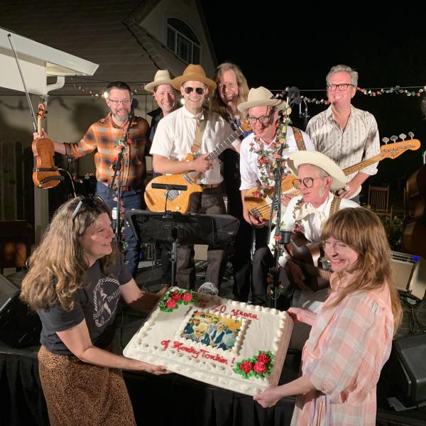 Bottom Dwellers receive a cake on stage at their 20th anniversary party