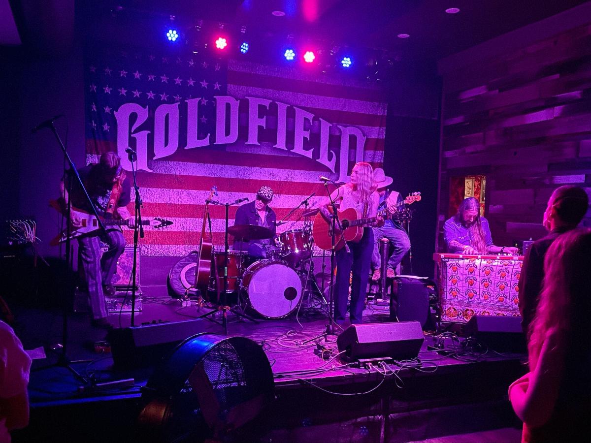 Kassi Valazza performs on a small stage with a five-piece band at Golfdield Trading Post in Sacramento, CA